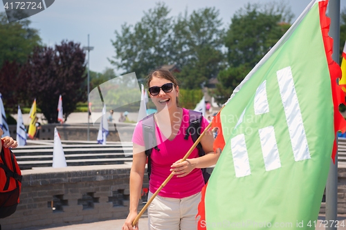 Image of Cheerful woman holding flag