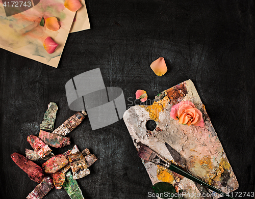 Image of paint brushes and tubes of oil paints on wooden background