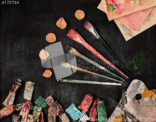 Image of paint brushes and tubes of oil paints on wooden background