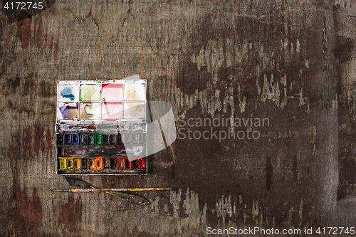 Image of paint brushes and tubes of oil paints on wooden background