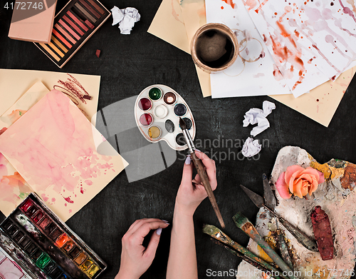 Image of paint brushes and tubes of oil paints on wooden background