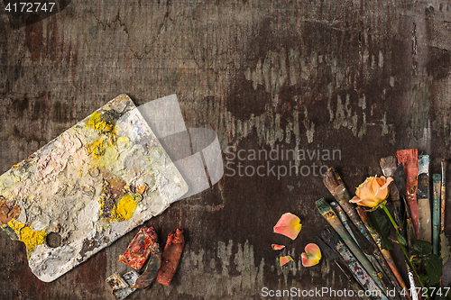 Image of paint brushes and tubes of oil paints on wooden background