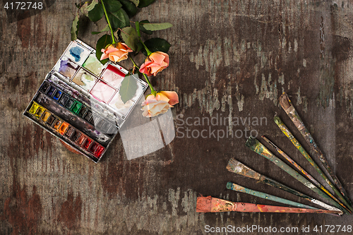 Image of paint brushes and tubes of oil paints on wooden background