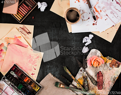 Image of paint brushes and tubes of oil paints on wooden background