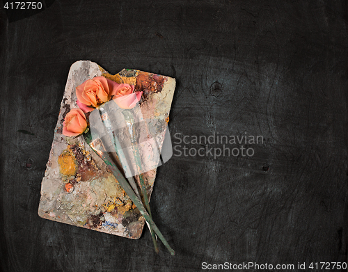 Image of paint brushes and tubes of oil paints on wooden background