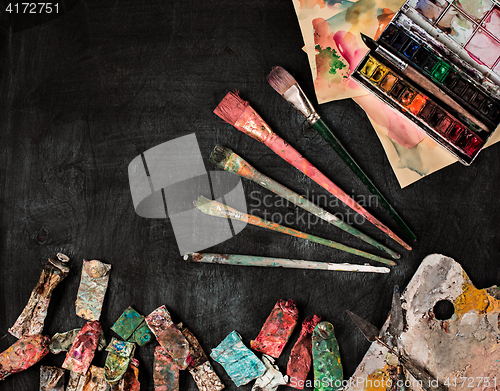 Image of paint brushes and tubes of oil paints on wooden background