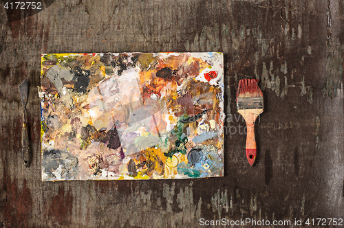 Image of paint brushes and tubes of oil paints on wooden background