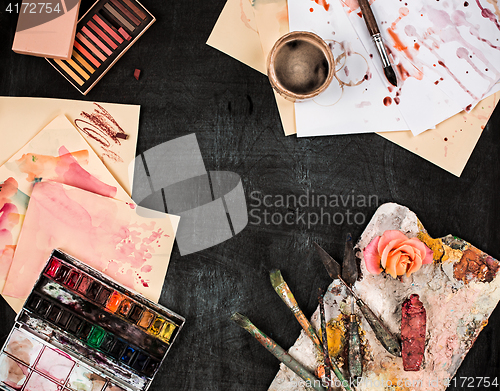 Image of paint brushes and tubes of oil paints on wooden background