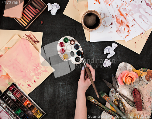 Image of paint brushes and tubes of oil paints on wooden background