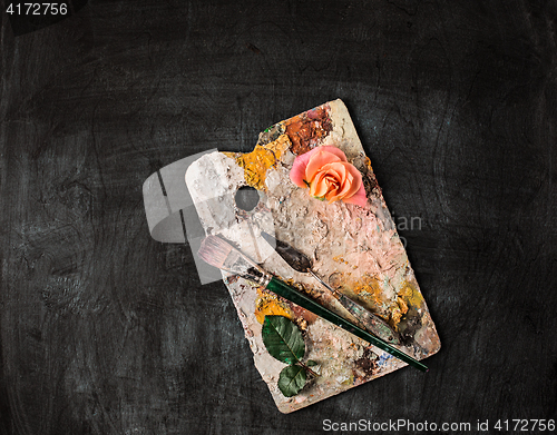 Image of paint brushes and tubes of oil paints on wooden background