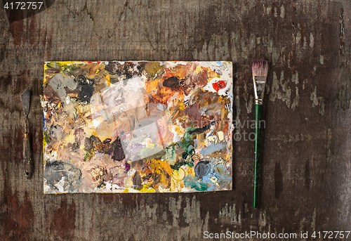 Image of paint brushes and tubes of oil paints on wooden background