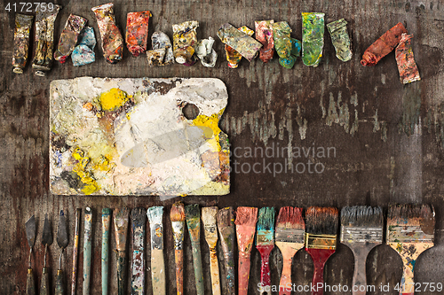 Image of paint brushes and tubes of oil paints on wooden background