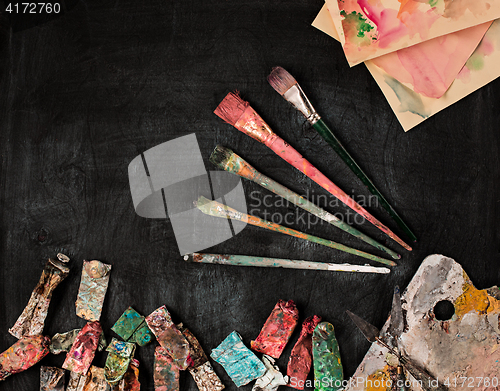 Image of paint brushes and tubes of oil paints on wooden background