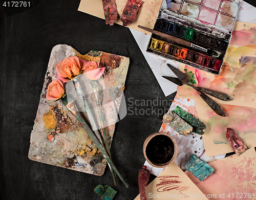 Image of paint brushes and tubes of oil paints on wooden background