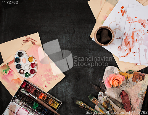 Image of paint brushes and tubes of oil paints on wooden background