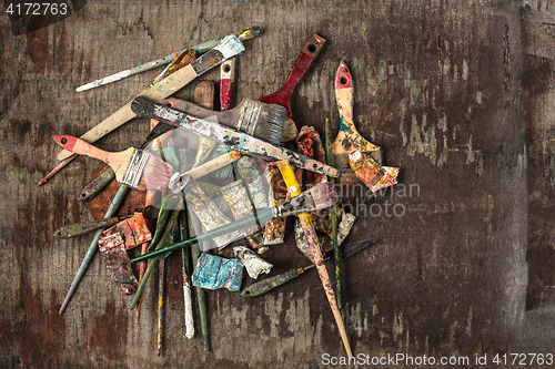 Image of paint brushes and tubes of oil paints on wooden background