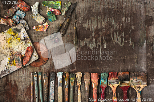 Image of paint brushes and tubes of oil paints on wooden background