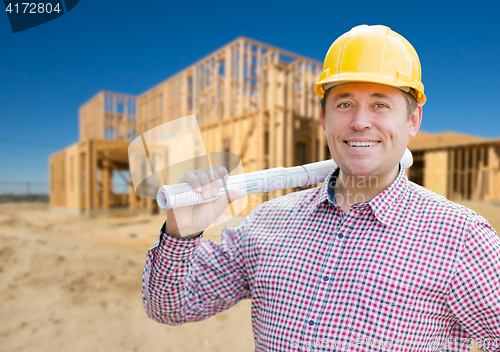 Image of Smiling Contractor Wearing Hardhat Holding Blueprints at Home Co