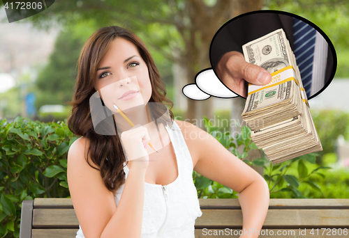 Image of Thoughtful Young Woman with Hand Holding Stack of Money Inside T