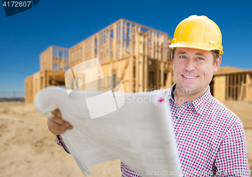 Image of Smiling Contractor Wearing Hardhat Holding Blueprints at Home Co