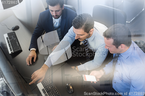Image of Business team analyzing data on computer.