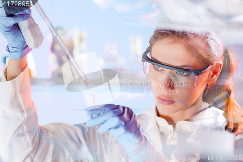 Image of Young scientist pipetting in life science laboratory.