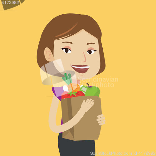 Image of Happy woman holding grocery shopping bag.