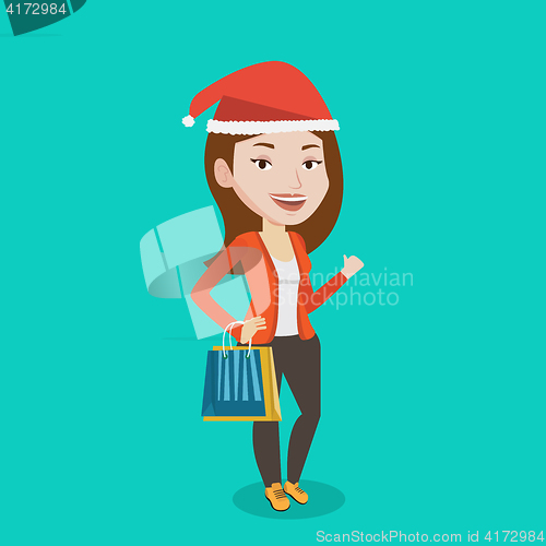 Image of Woman in santa hat shopping for christmas gifts.
