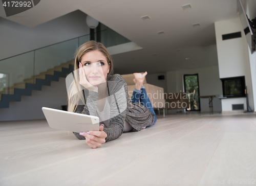 Image of young women used tablet computer on the floor