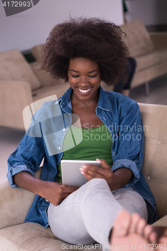 Image of african american woman at home with digital tablet