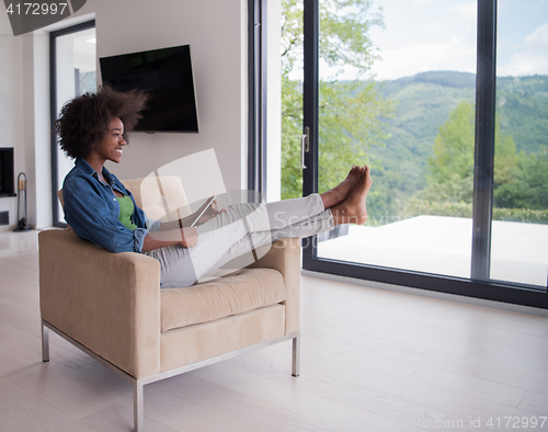 Image of african american woman at home with digital tablet