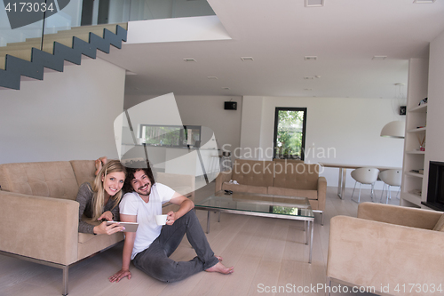 Image of couple relaxing at  home with tablet computers