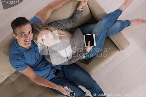Image of youg couple in living room with tablet top view