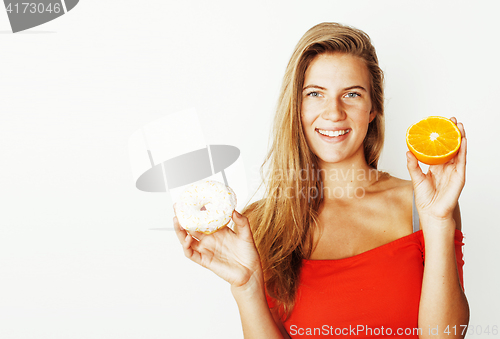 Image of young blonde woman choosing between donut and apple fruit isolat