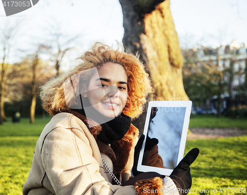 Image of young cute blond african american girl student holding tablet an