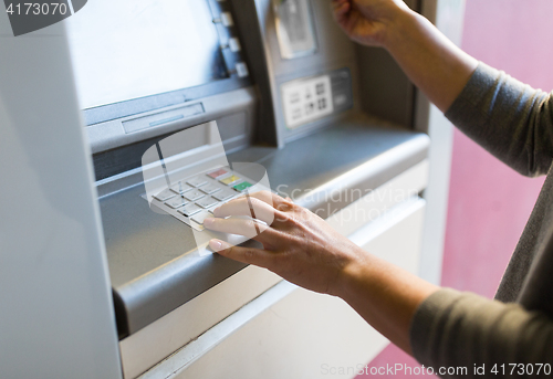 Image of close up of hand entering pin code at atm machine