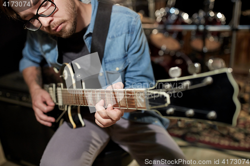 Image of man playing guitar at studio rehearsal