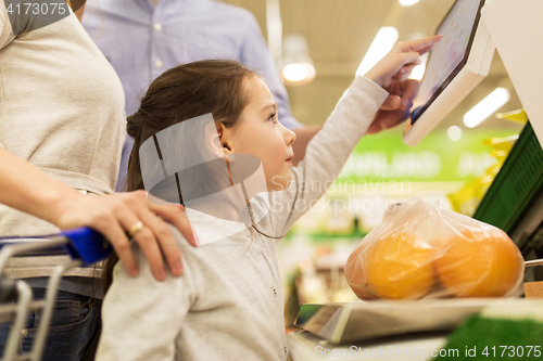 Image of family weighing oranges on scale at grocery store