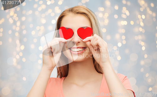 Image of happy young woman with red heart shapes on eyes