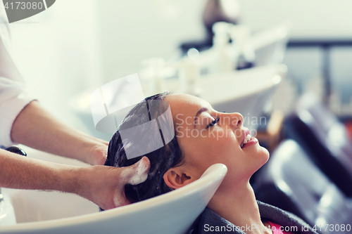 Image of happy young woman at hair salon