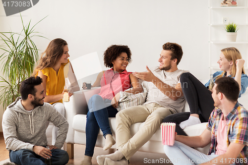 Image of happy friends with popcorn and beer at home