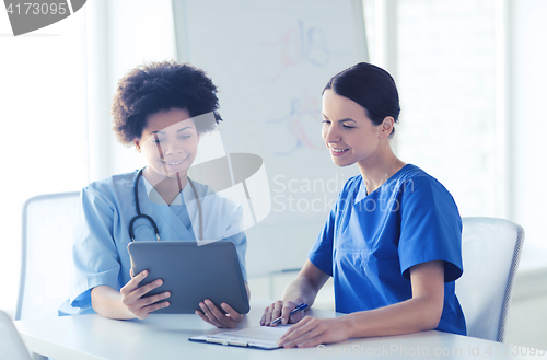 Image of happy doctors with tablet pc meeting at hospital