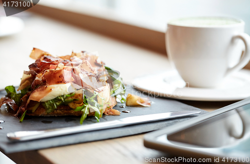 Image of prosciutto ham salad on stone plate at restaurant