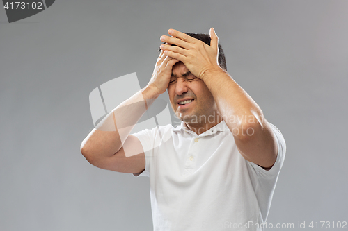 Image of unhappy man suffering from head ache