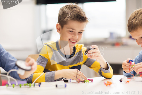 Image of happy boy building robot at robotics school