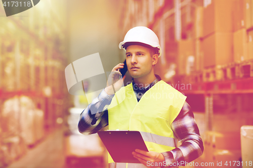 Image of man with clipboard and smartphone at warehouse