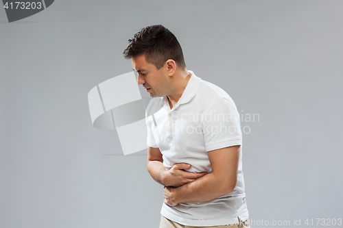 Image of unhappy man suffering from stomach ache