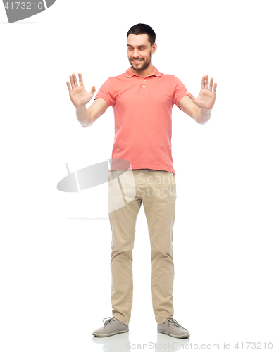 Image of happy man touching something imaginary