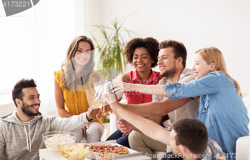 Image of friends having party and clinking drinks at home