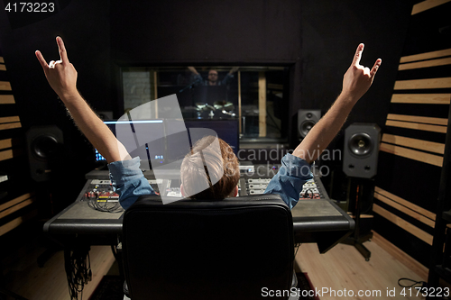 Image of man at mixing console in music recording studio